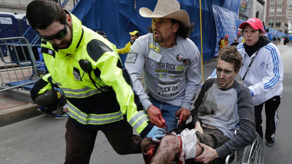 PHOTO: Boston Marathon bombing survivor Jeff Bauman is helped by Emergency Medical Services EMT Paul Mitchell, left, Carlos Arredondo, center, and Devin Wang, right, after he was injured in one of two explosions in Boston, April 15, 2013.