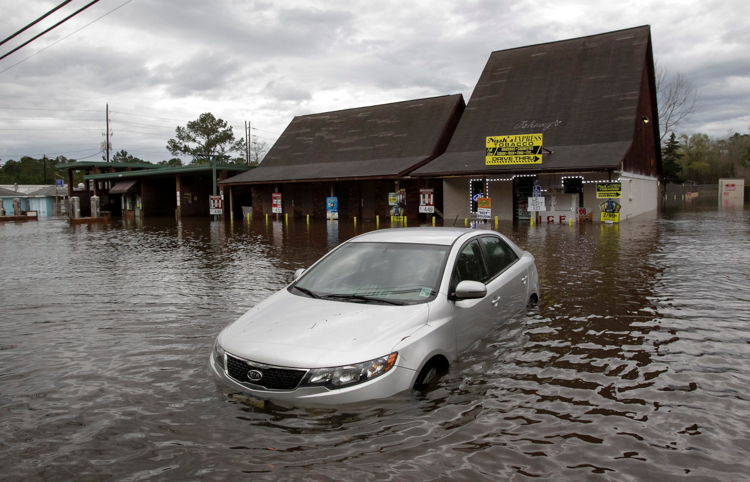 PHOTO: A car sits in flooded water at Nash's Express convenience store in Hammond, La., March 11, 2016. 