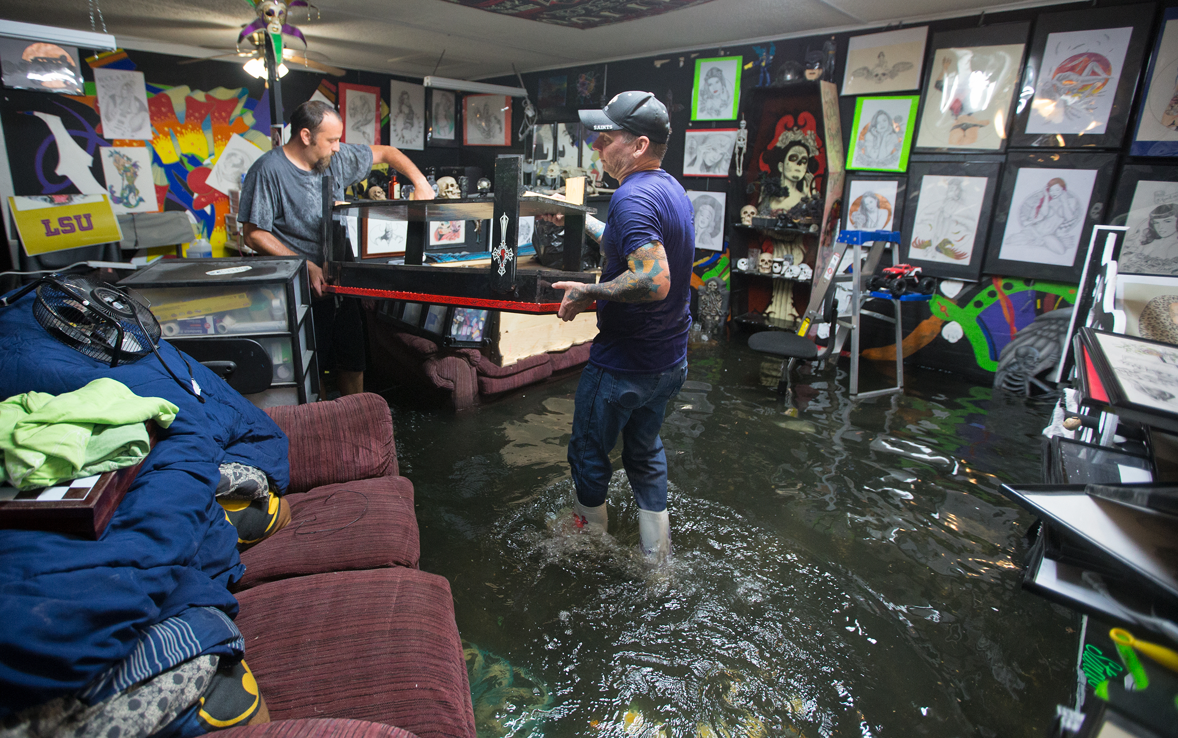 PHOTO: Brad Gilbert, left, helps his friend Mike Abel with his flooded business in Amite, Louisiana, picking up anything that is salvageable before the water gets higher, Aug. 12, 2016. 