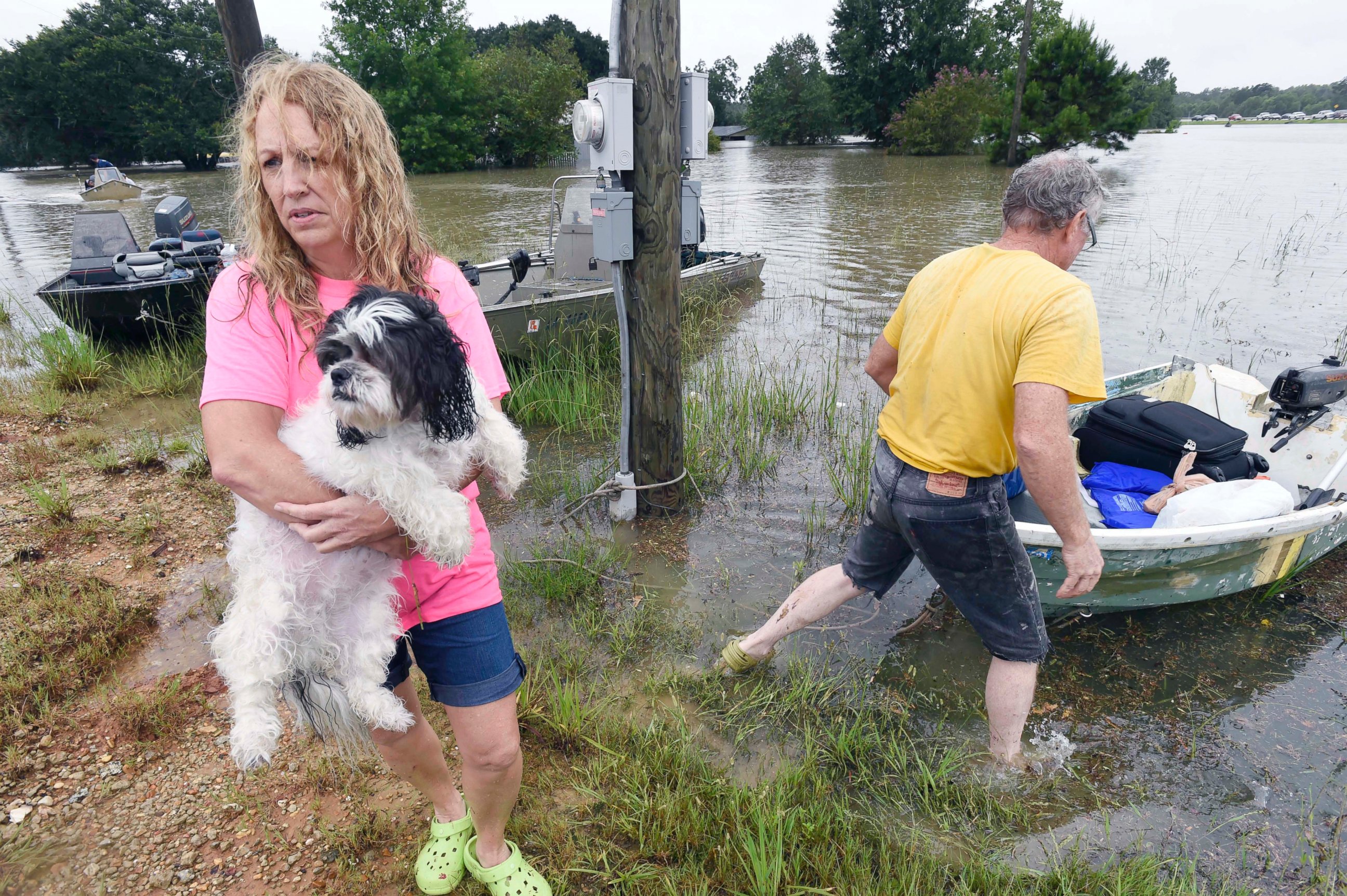 PHOTO: Tammie Wise holds her dog Mikey, after Jeffrey Lesage, right, boated them to safety in Central, Louisiana, Aug. 13, 2016. 
