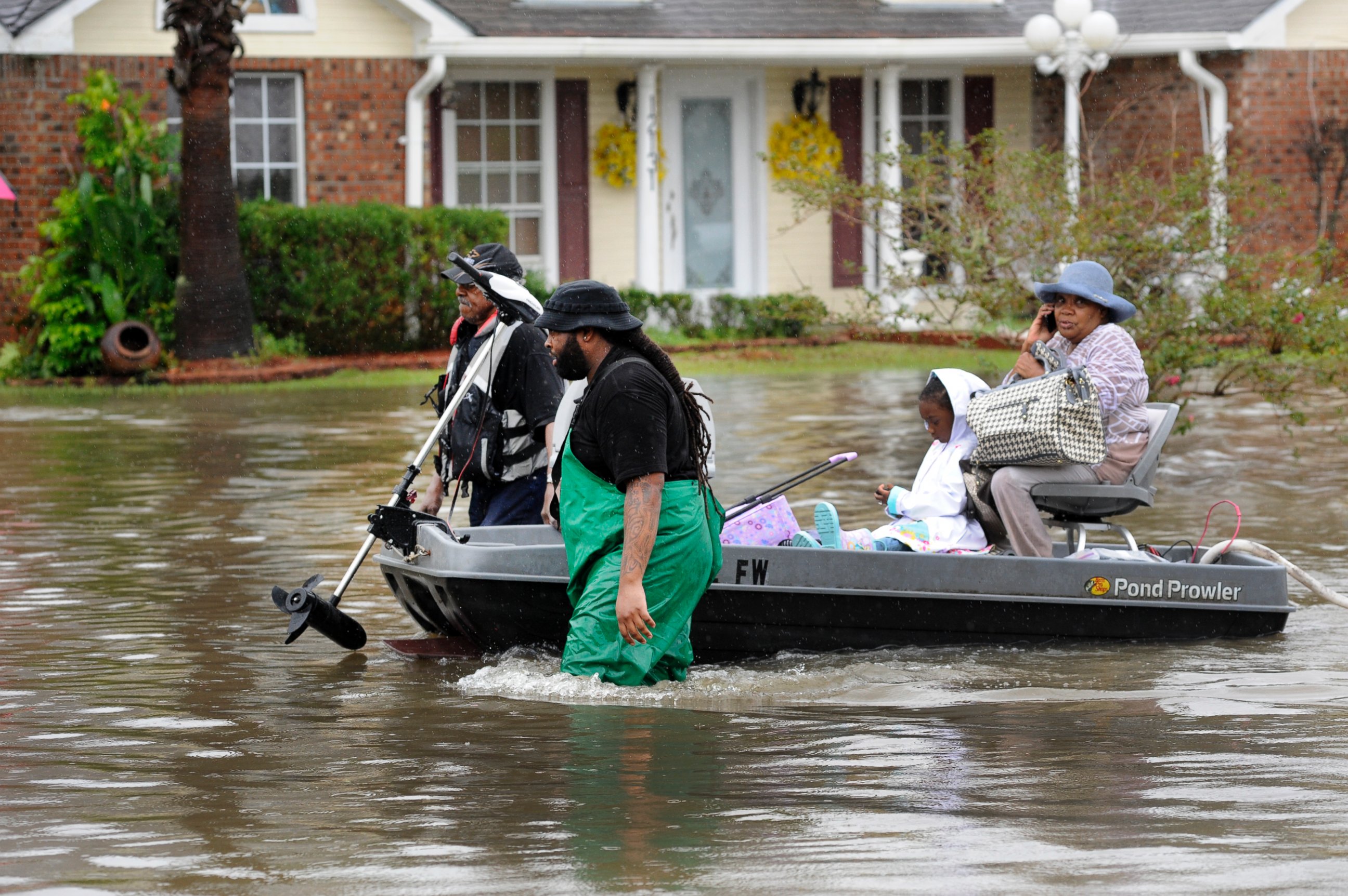 PHOTO: Volunteers pull a boat with a woman and young child as they evacuate from their homes, Aug. 13, 2016, in Baton Rouge, Louisiana.