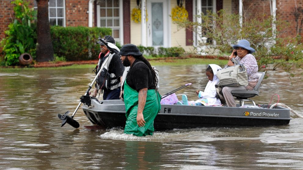 PHOTO: Volunteers pull a boat with a woman and young child as they evacuate from their homes, Aug. 13, 2016, in Baton Rouge, Louisiana.