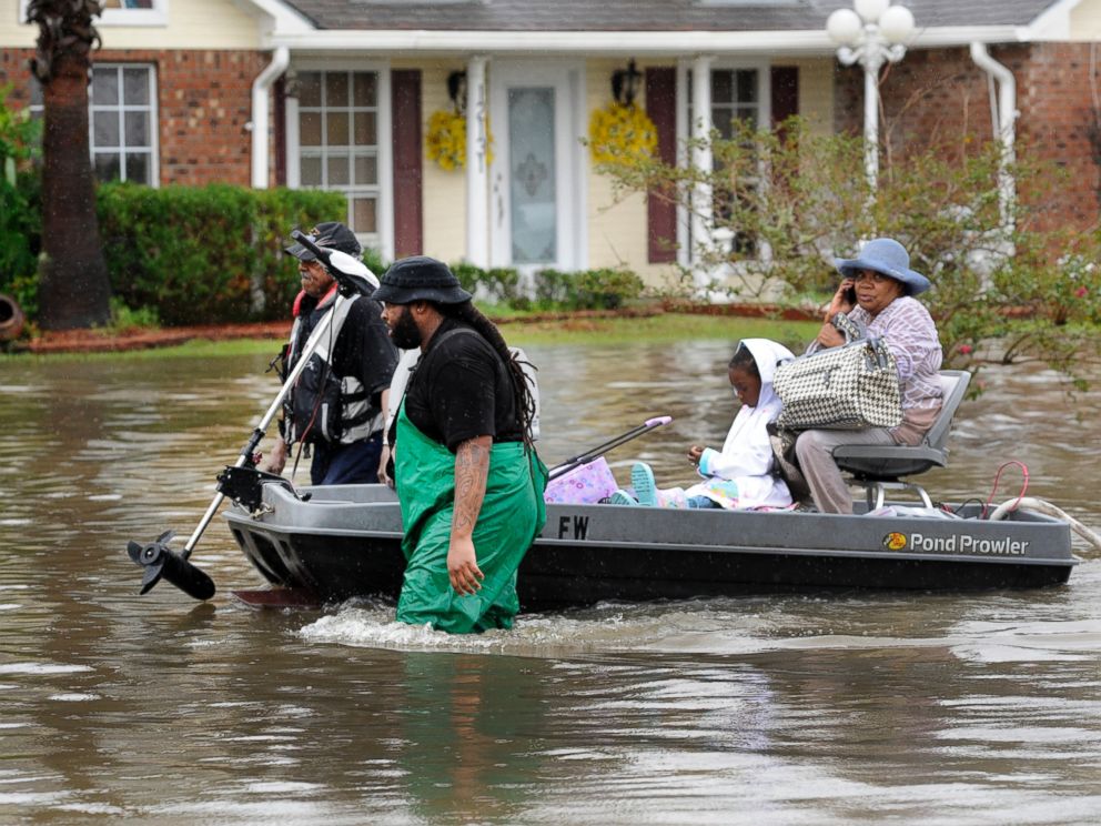 PHOTO: Volunteers pull a boat with a woman and young child as they evacuate from their homes, Aug. 13, 2016, in Baton Rouge, Louisiana.