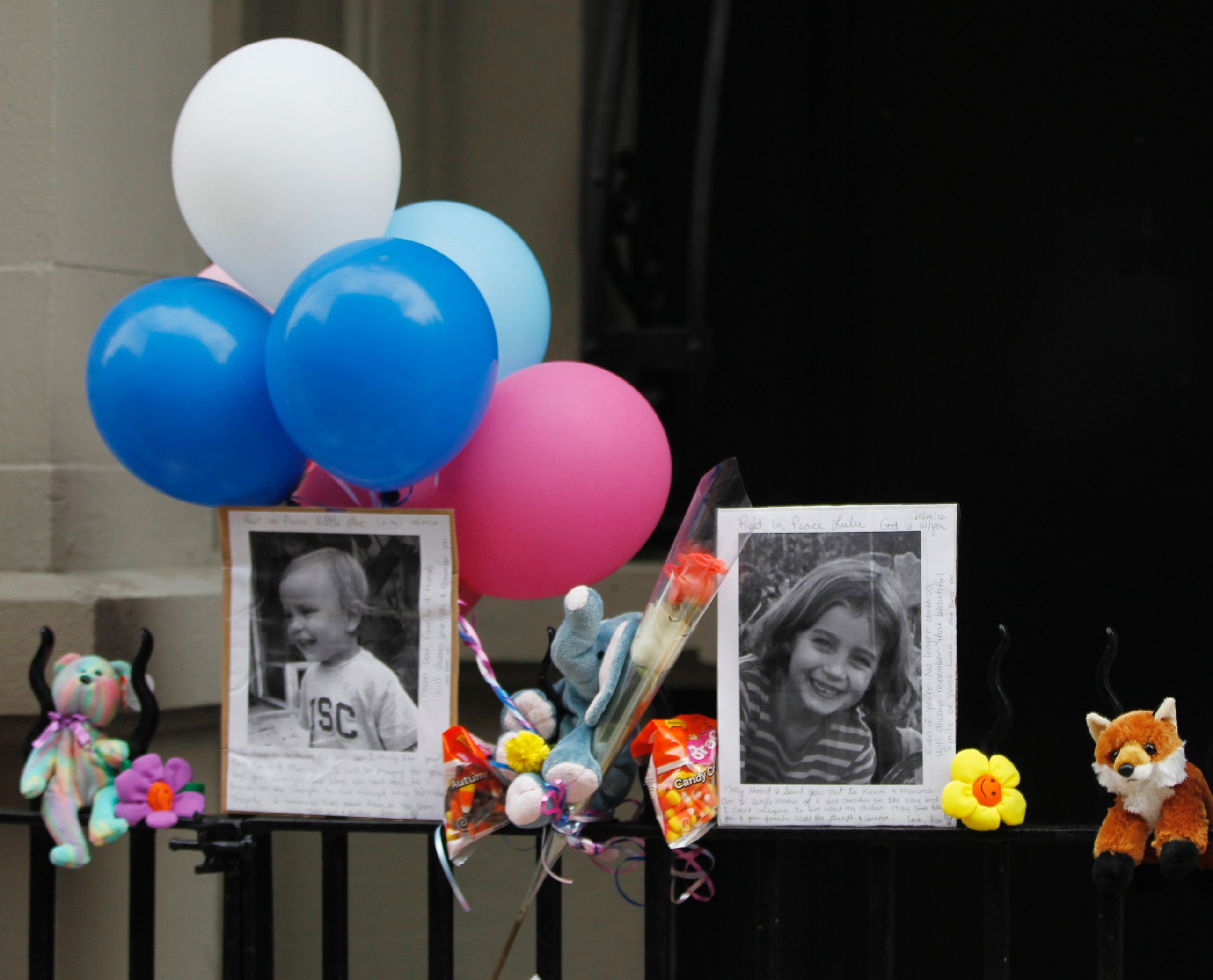 PHOTO: Photographs of six-year-old Lucia Krim and her 2-year-old brother, Leo, are displayed alongside balloons and stuffed animals at a memorial outside the apartment building were they lived in New York, Oct. 27, 2012.