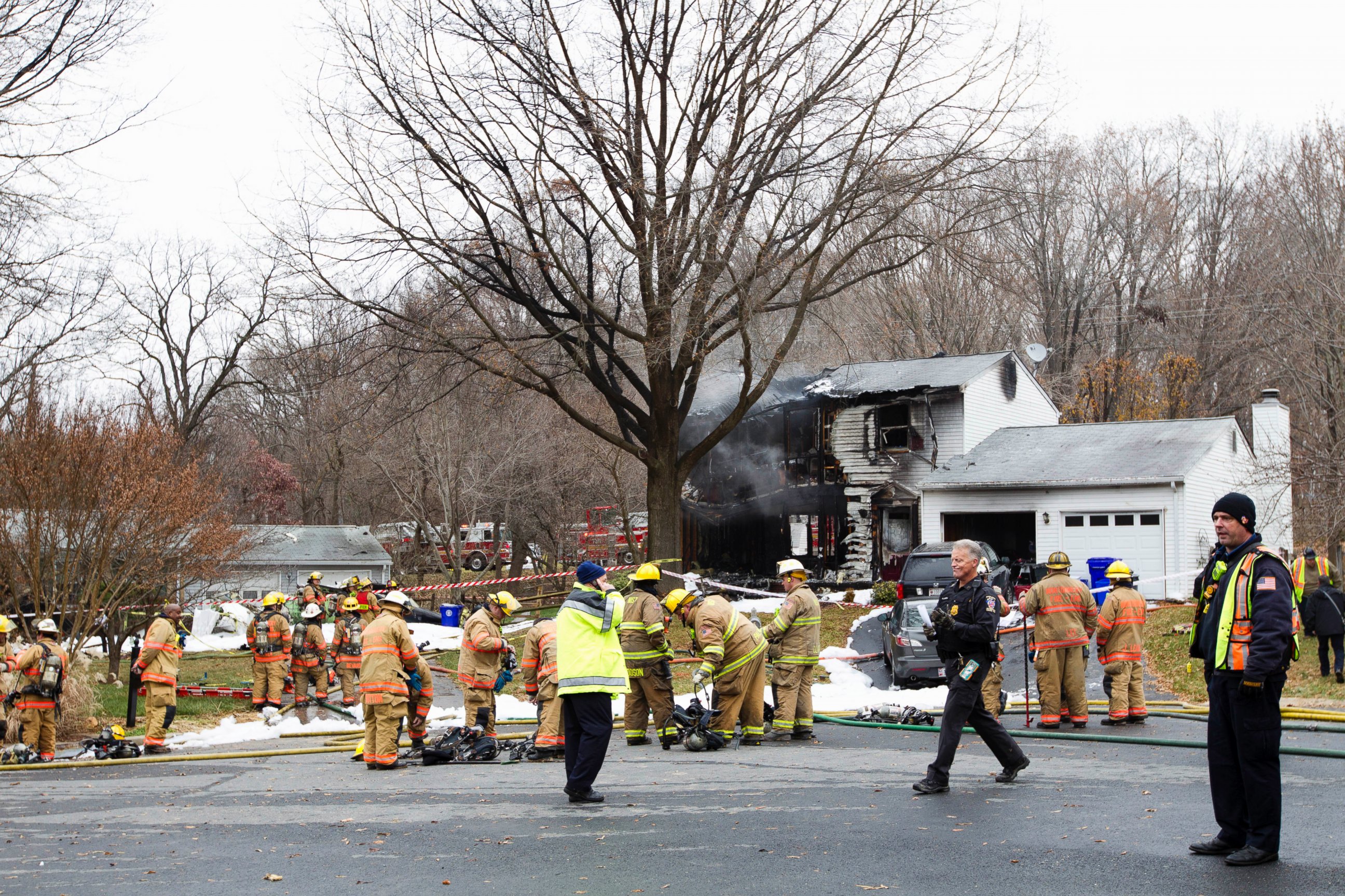 PHOTO: Montgomery County, Md. firefighters stand outside a house where a small plane crashed in Gaithersburg, Md., Dec. 8, 2014.