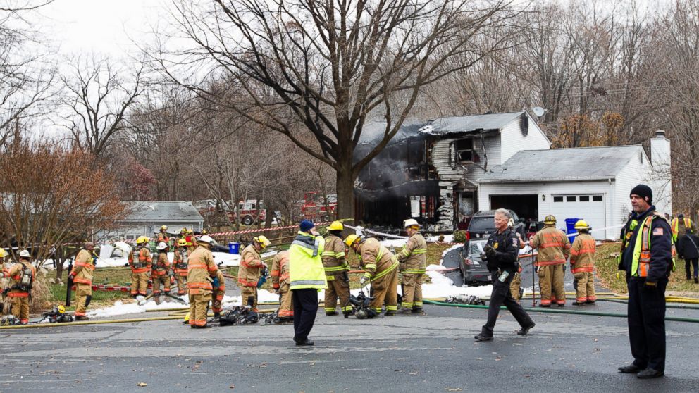 PHOTO: Montgomery County, Md. firefighters stand outside a house where a small plane crashed in Gaithersburg, Md., Dec. 8, 2014.