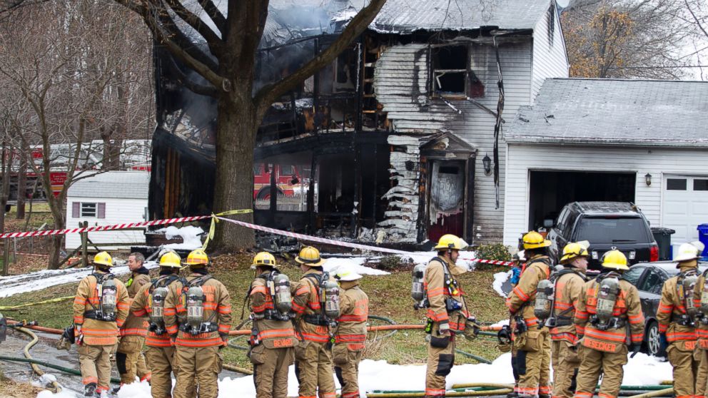 PHOTO: Montgomery County, Md. firefighters stand outside a house where a small plane crashed in Gaithersburg, Md. on Dec. 8, 2014. 