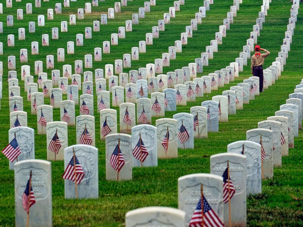 PHOTO: A Boy Scout salutes at the foot of a grave after volunteers placed flags at the Los Angeles National Cemetery, May 28, 2016 in preparation for Memorial Day.