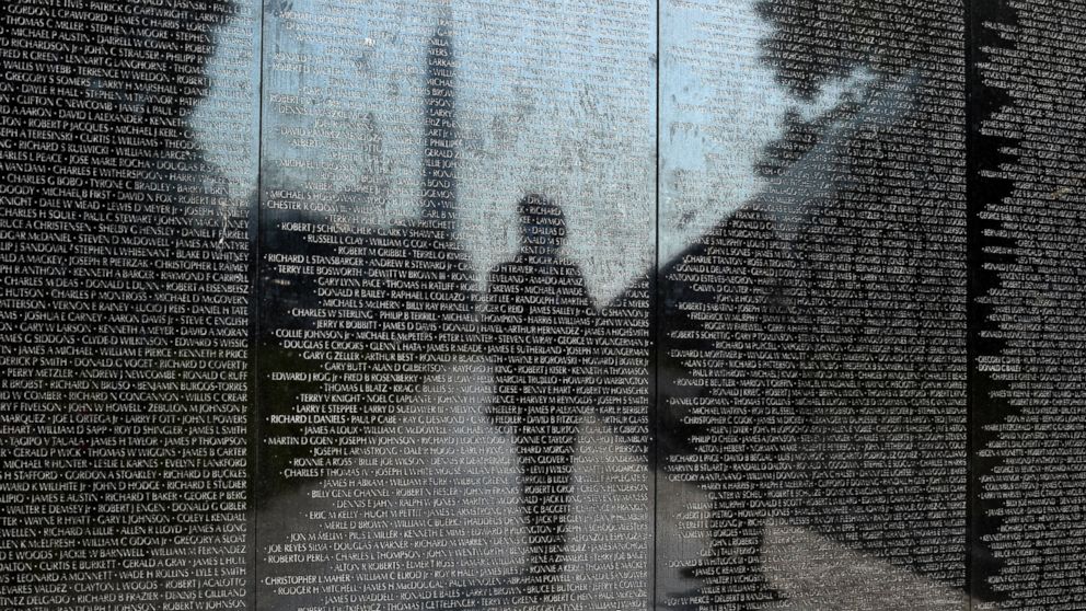 PHOTO: Visitors are reflected in the Vietnam Memorial in Washington, May 27, 2016. 