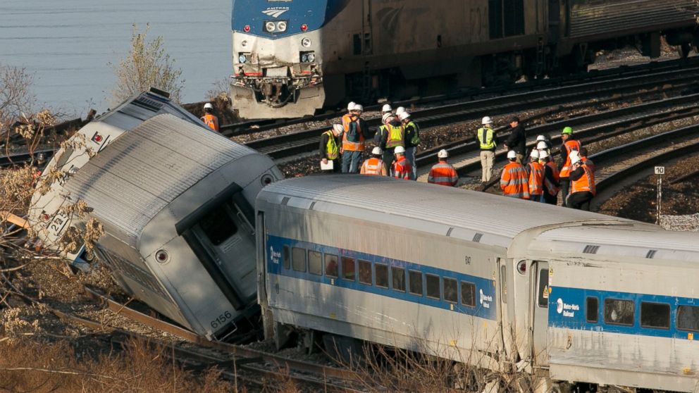 An Amtrak train traveling on an unaffected track, passes a derailed Metro North commuter train, Dec. 1, 2013, in the Bronx, New York.
