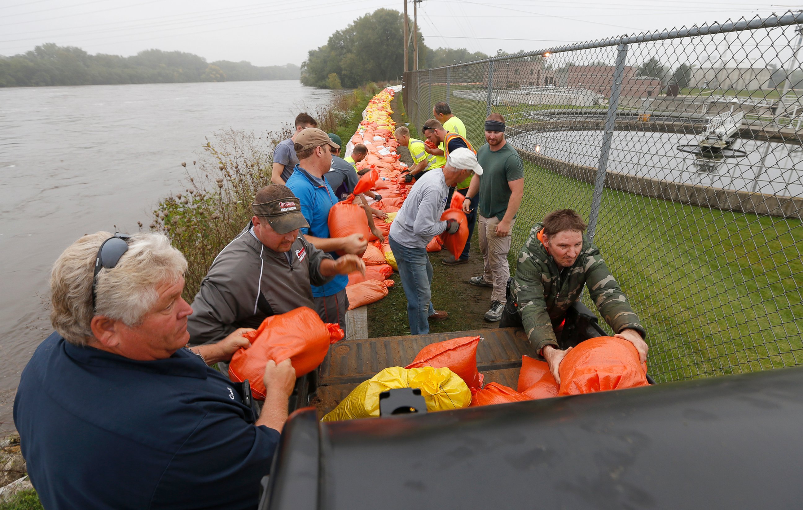 PHOTO: Volunteers and city workers place sandbags along the dike between the Cedar River and the water treatment plant in Cedar Falls, Iowa, Sept.  24, 2016. 