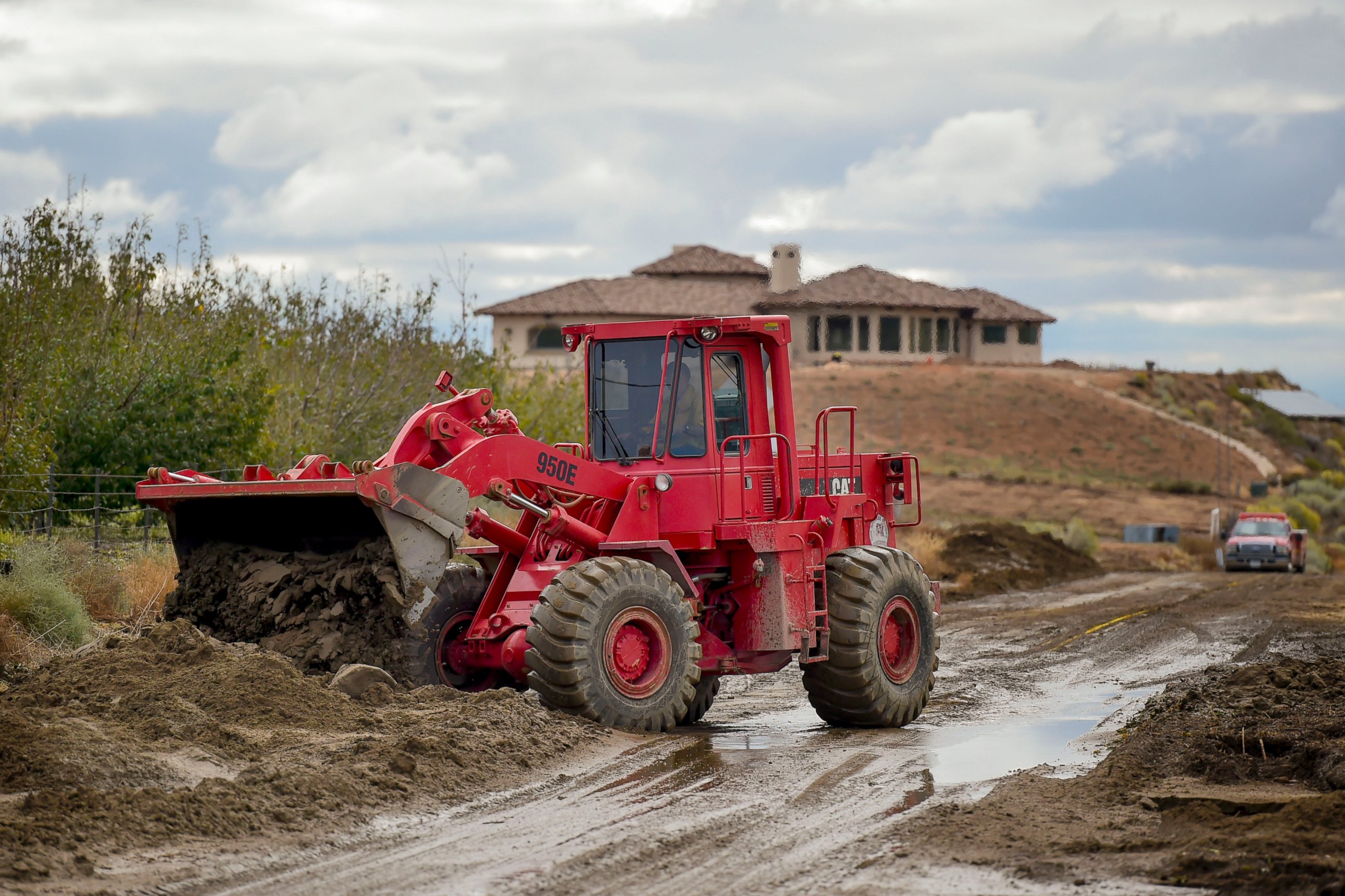 PHOTO: A Los Angeles County firefighter use a front end loader to clear mud on Friday, Oct. 16, 2015, after a flash floods the day before sent mud and debris through Elizabeth Lake road in Leona Valley, Calif., trapping cars and closing roads. 
