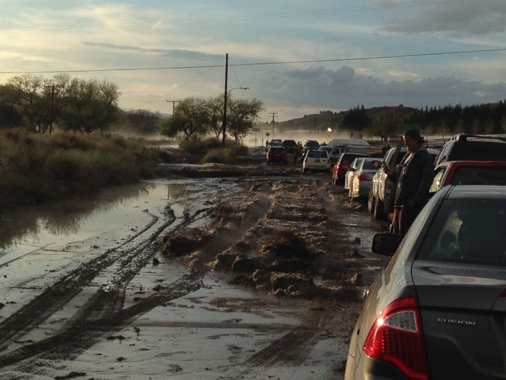 PHOTO: Cars on a road are stopped because of flooding, with some stuck in the mud in the distance, in Lake Hughes, Calif, Oct. 15, 2015. 