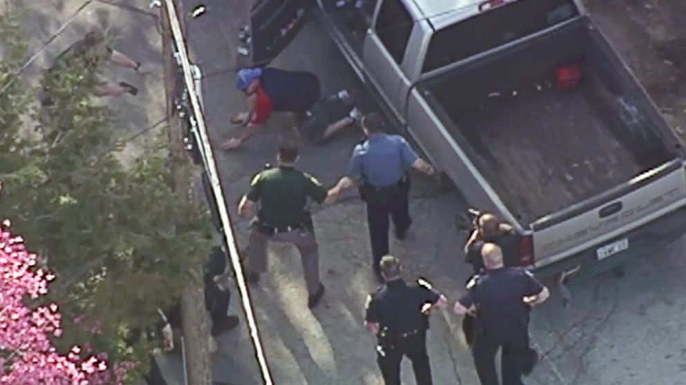This aerial image made from a helicopter video provided by WHDH shows Richard Simone kneeling and putting his hands on the ground after a high-speed police pursuit in Nashua, N.H., May 11, 2016.