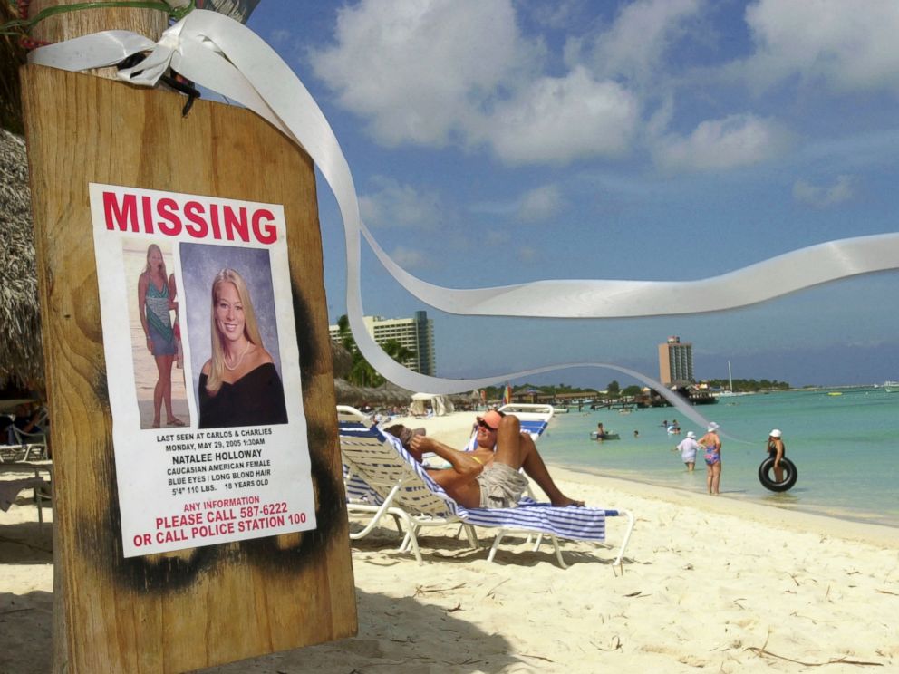 PHOTO: A missing poster for Natalee Holloway, a high school graduate of Mountain Brook, Alabama who disappeared while on a graduation trip to Aruba on May 30, 2005, is seen on Palm Beach where tourists sunbathe in Aruba, June 10, 2005.
