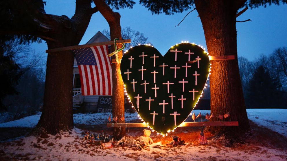 A memorial with crosses for the victims of the Sandy Hook Elementary School shooting massacre stands outside a home in Newtown, Conn., on the one-year anniversary of the shootings, Dec. 14, 2013.