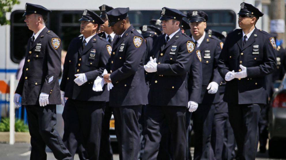 Police officers, mostly from the 105th Precinct in the Queens borough of New York, enter the wake for New York City police officer Brian Moore Thursday, May 7, 2015, in Bethpage, N.Y.