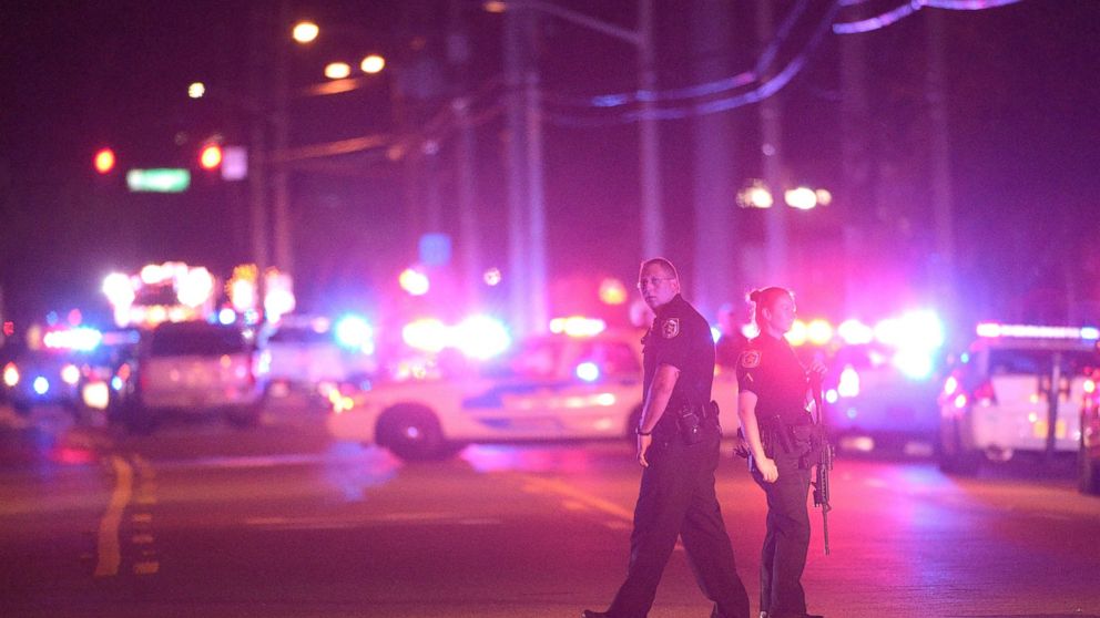 Police officers stand guard down the street from the scene of a shooting involving multiple fatalities at a nightclub in Orlando, Fla., June 12, 2016. 