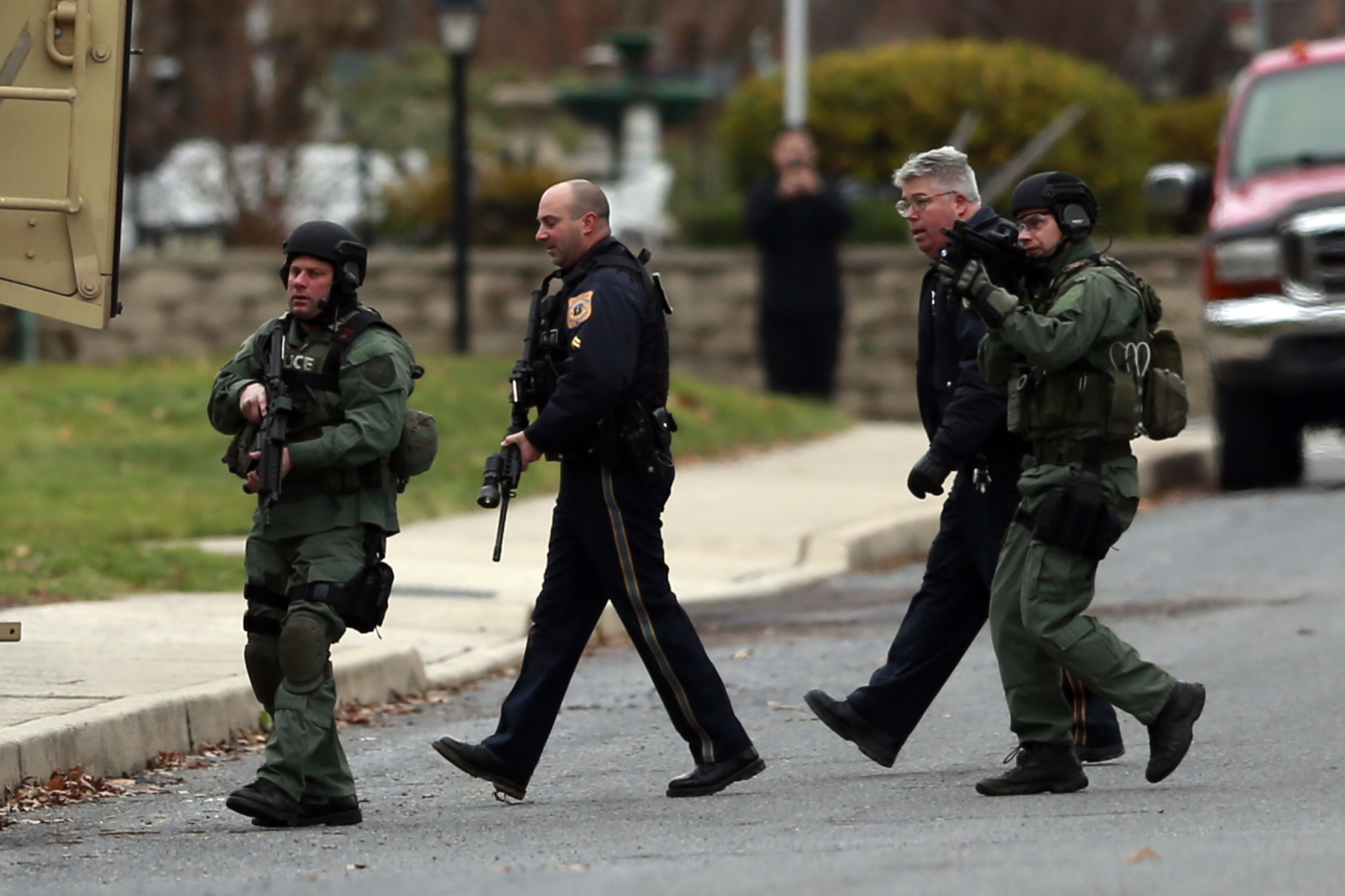 PHOTO: Police move near a home where a suspect is believed to have barricaded himself inside