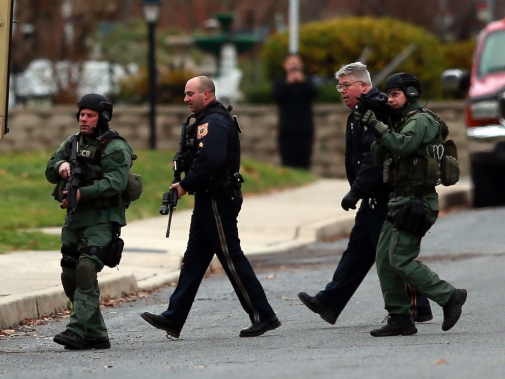 PHOTO: Police move near a home where a suspect is believed to have barricaded himself inside