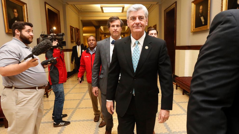 PHOTO: Republican Gov. Phil Bryant, right, walks past reporters on his way to a meeting of a youth jobs program board, at the Capitol in Jackson, Miss., April 1, 2016. 