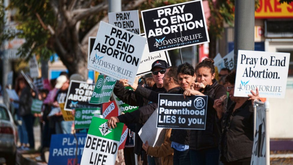 Protesters carry signs outside a Planned Parenthood health center in the Van Nuys section of Los Angeles, Feb. 11, 2017. 