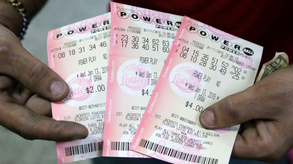 A customer shows his purchased Powerball tickets at a grocery store in Hialeah, Fla., Jan. 11, 2016.