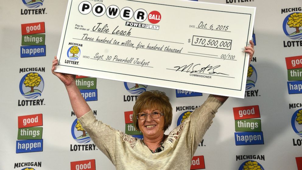 PHOTO: Julie Leach holds her $310 Million check aloft on Oct. 6, 2015. She was the sole winner of the Powerball jackpot.