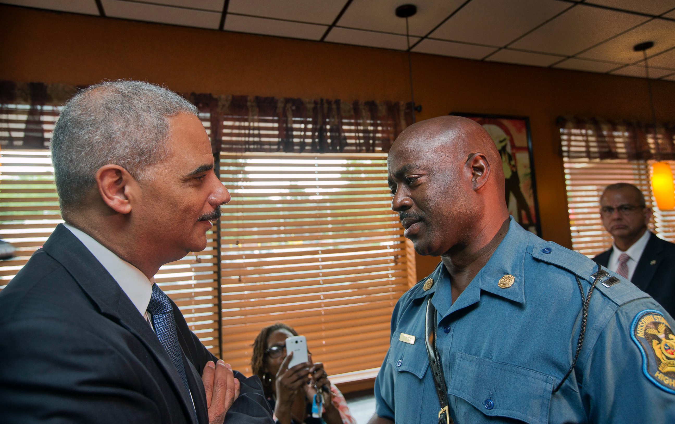 PHOTO: Attorney General Eric Holder speaks with Capt. Ron Johnson of the Missouri State Highway Patrol at Drake's Place Restaurant in Ferguson, Mo., in this Aug. 20 2014 file-pool photo.