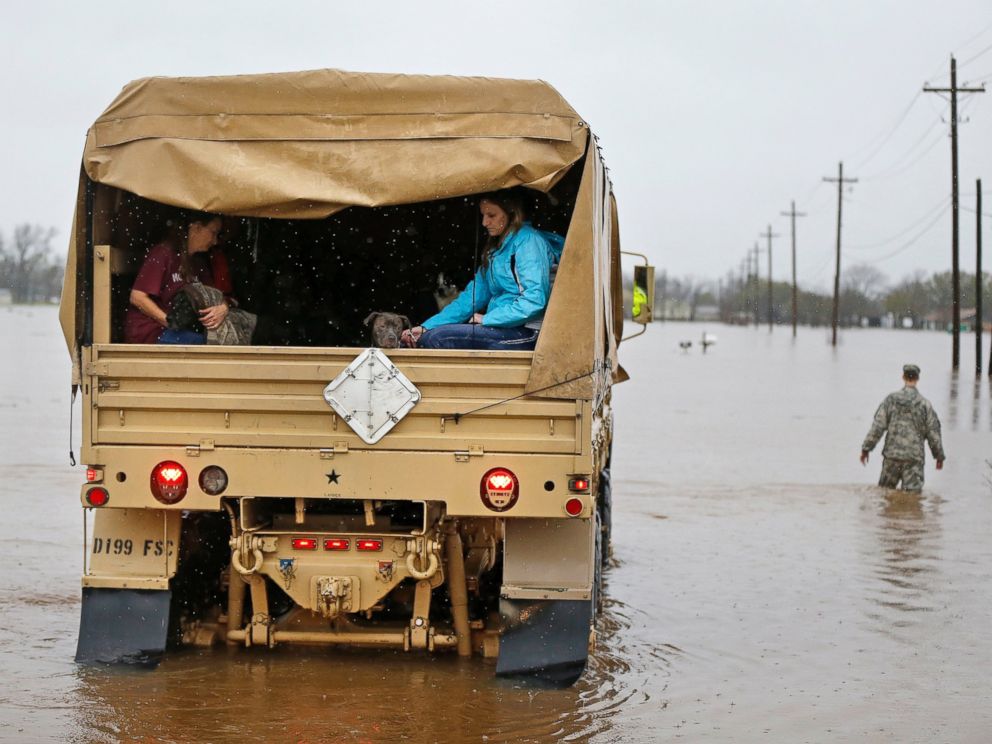 PHOTO: People sit in the back of a Louisiana National Guard truck as they are evacuated from rising floodwaters in Bossier Parish, La., March 10, 2016.