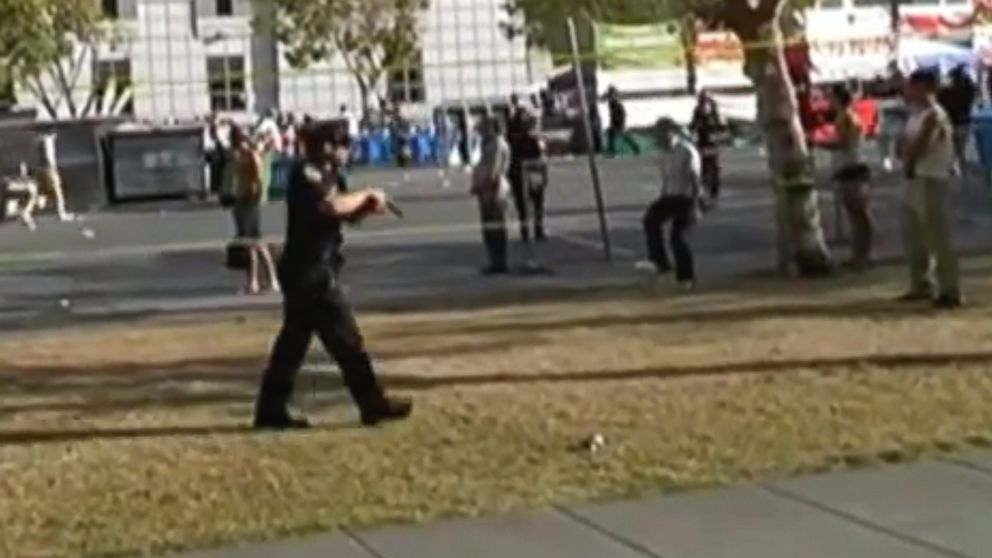 In this image taken from video provided by Sean-Franc Strang, a police officer has his gun drawn after shots were fired at a gay pride event in San Francisco, June 27, 2015.