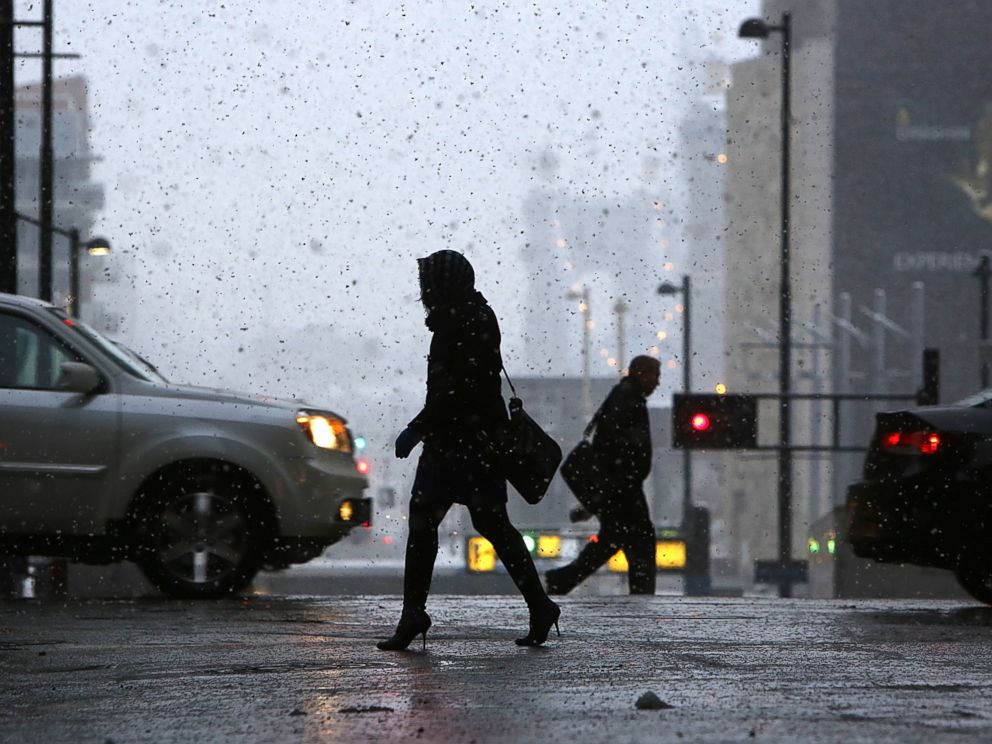 PHOTO:: Pedestrians make their way through downtown Cincinnati, Nov. 17, 2014, as the season's first snowfall resulted in thousands of power outages in the Cincinnati area.