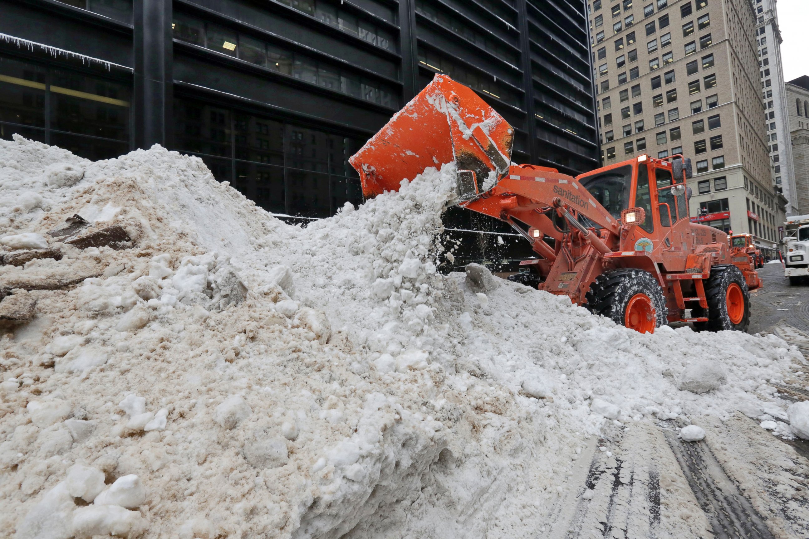 PHOTO: A New York City Department of Sanitation front end loader unloads collected snow for melting, near the World Trade Center site, in New York, Jan. 25, 2016. 