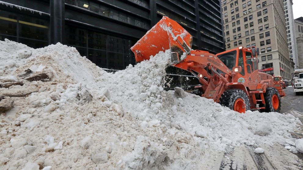 PHOTO: A New York City Department of Sanitation front end loader unloads collected snow for melting, near the World Trade Center site, in New York, Jan. 25, 2016. 
