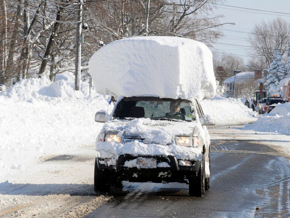 PHOTO: A vehicle, with a large chunk of snow on its top, drives along Route 20 after digging out after a massive snow fall in Lancaster, N.Y., Nov. 19, 2014.