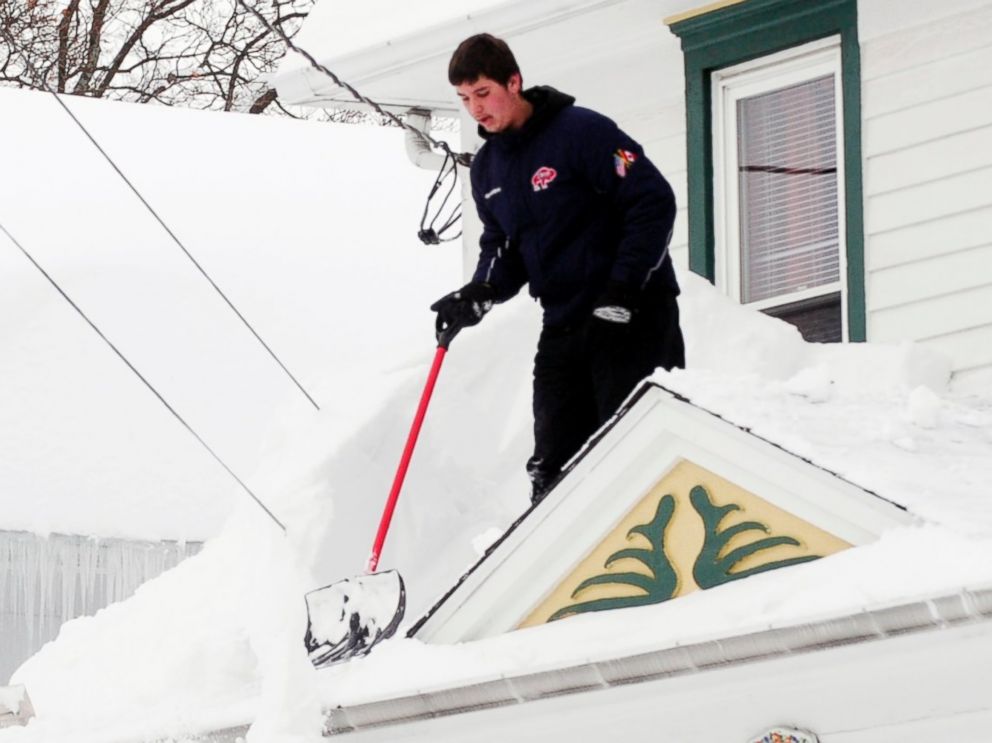 PHOTO: Andrew Zelak cleans the snow from his roof on Irving Place in Alden, N.Y., Nov. 20, 2014.