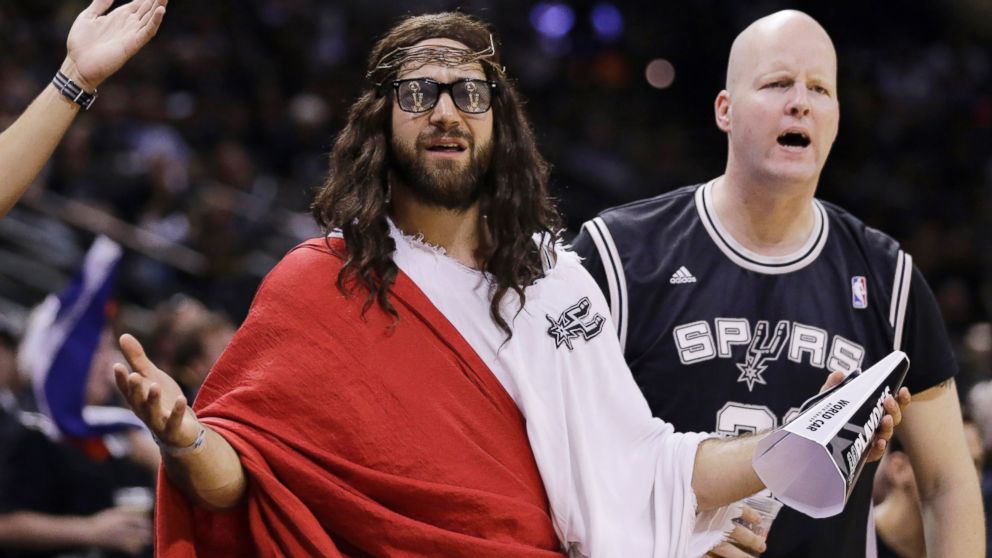 Fans, including "Spurs Jesus", center, react to a call during the second half in Game 1 of the NBA basketball finals between the San Antonio Spurs and the Miami Heat, June 5, 2014 in San Antonio.