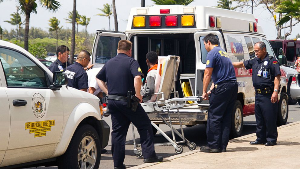 A 15-year-old boy, seen sitting on a stretcher center, who stowed away in the wheel well of a flight from San Jose, Calif., to Maui is loaded into an ambulance at Kahului Airport in Kahului, Maui, Hawaii, April 20, 2014.