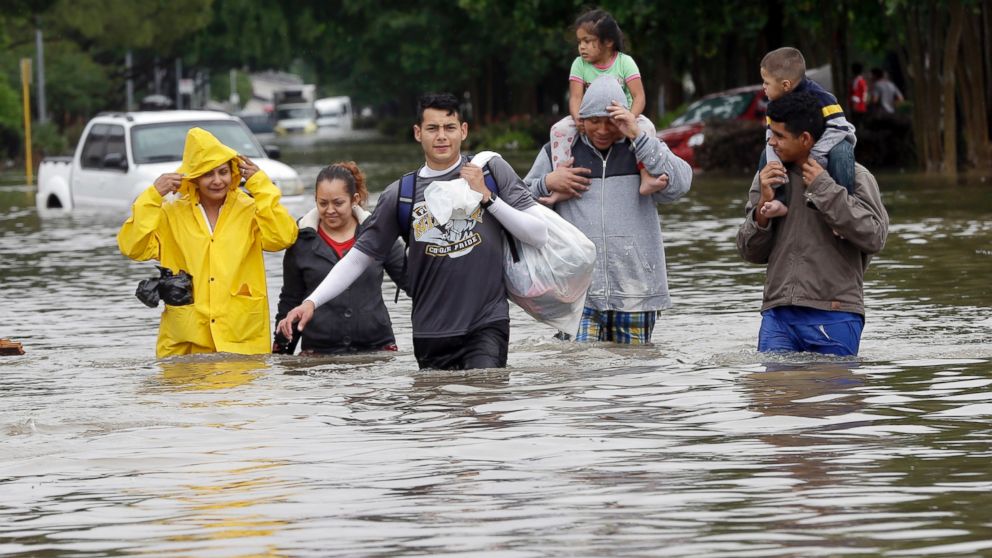 PHOTO: Residents wade through floodwaters as they evacuate from their flooded apartment complex, April 18, 2016, in Houston.