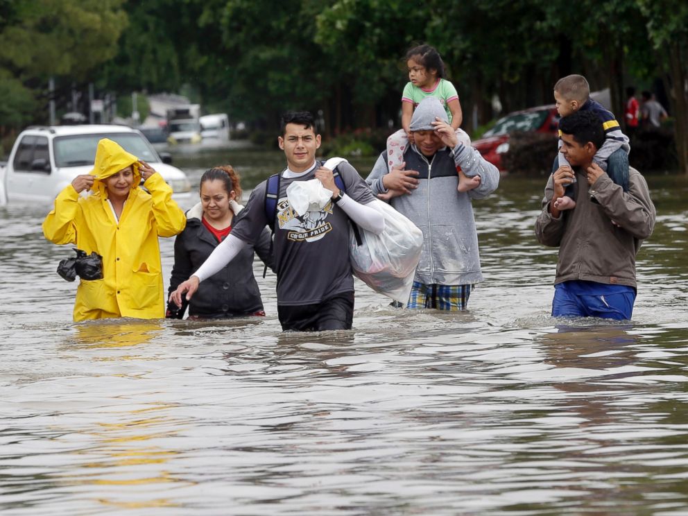 PHOTO: Residents wade through floodwaters as they evacuate from their flooded apartment complex, April 18, 2016, in Houston.