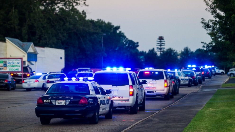 Lafayette Police Department and Louisiana State Police units block an entrance road following a shooting at The Grand Theatre in Lafayette, La., Thursday, July 23, 2015.