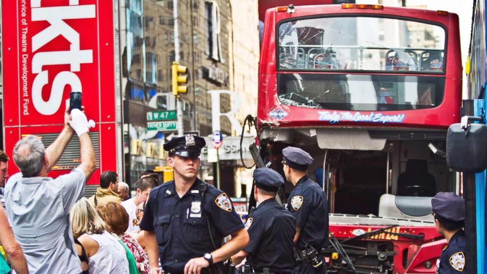 Police investigate the scene of a traffic accident involving two double-decker tour buses in New York City's Theater District, Aug. 5, 2014.