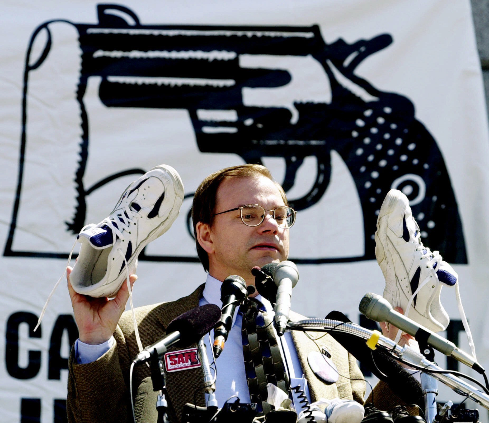 PHOTO: Tom Mauser holds up a pair of shoes belonging to his late son, Daniel, who was killed in the Columbine High School shooting, during a rally at the Capitol in Denver,  April 11, 2000. 