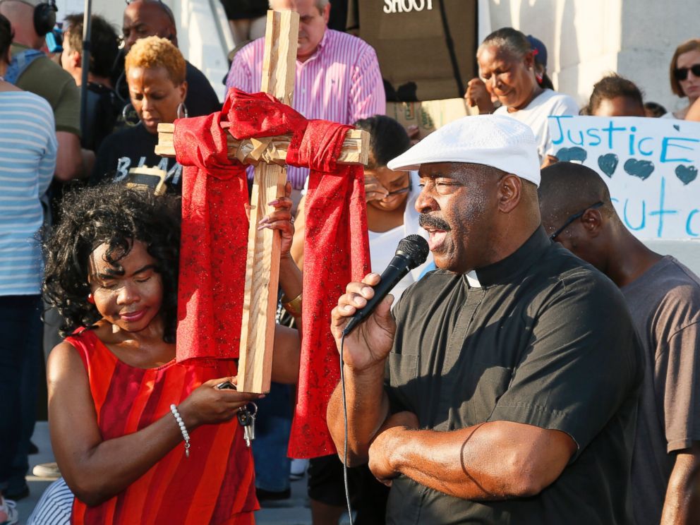 PHOTO: Mary Williams, left, bows her head as Pastor Allen Jamison, right, says a prayer at the start of a "protest for justice" over Friday's shooting death of Terence Crutcher, sponsored by We the People Oklahoma, in Tulsa, Oklahoma, Sept. 20, 2016.