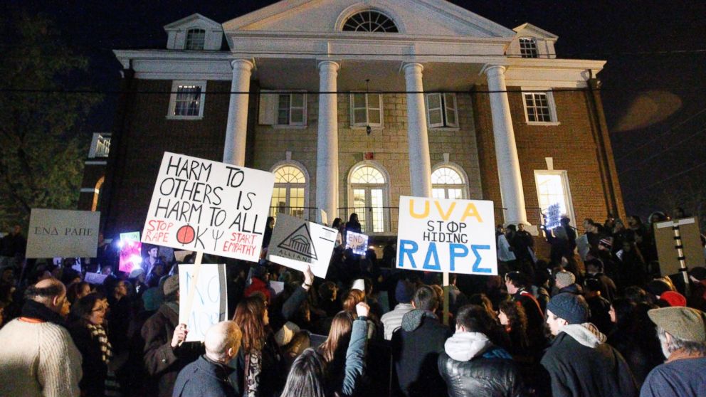 Protestors carry signs and chant slogans in front of the Phi Kappa Psi fraternity house at the University of Virginia, Nov. 22, 2014, in Charlottesville, Va. 
