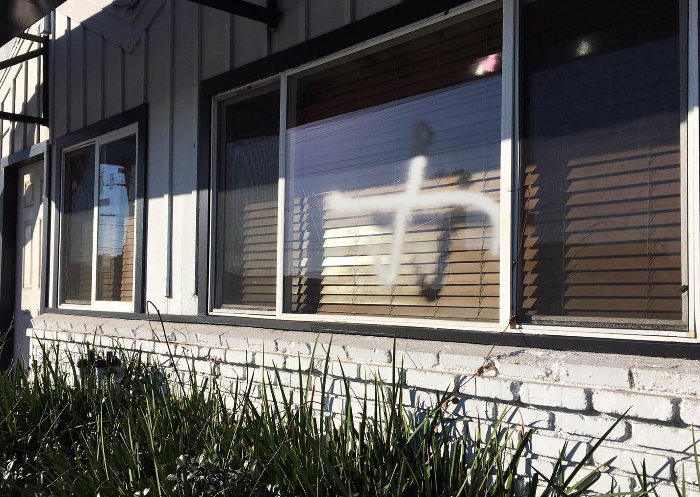 PHOTO:This photo provided by the Ahmadiyya Muslim Community muslimsforpeace.org shows crosses in spray paint vandalizing windows at the Ahmadiyya Muslim Community Baitus-Salaam Mosque in Hawthorne, Calif., Dec. 13, 2015. 