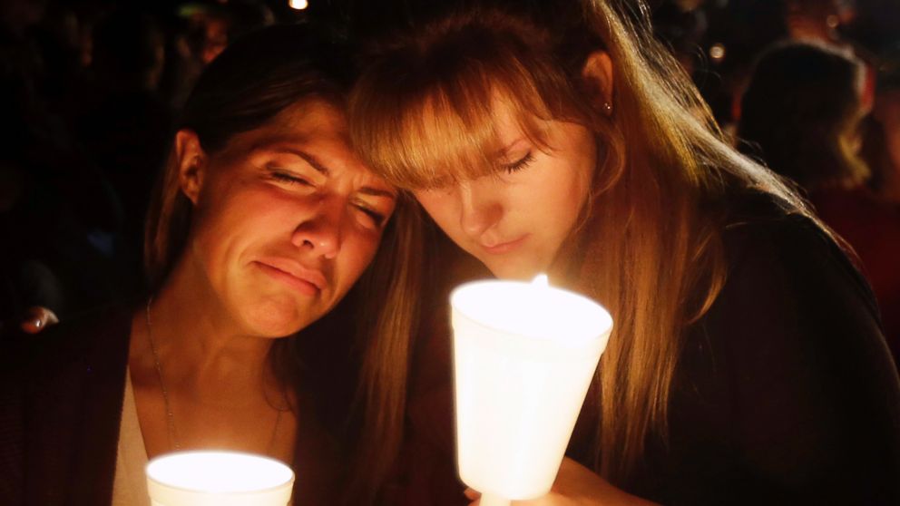 PHOTO: Kristen Sterner, left, and Carrissa Welding, both students at Umpqua Community College, embrace each other during a candlelight vigil for those killed during a shooting at the college, Oct. 1, 2015, in Roseburg, Ore.