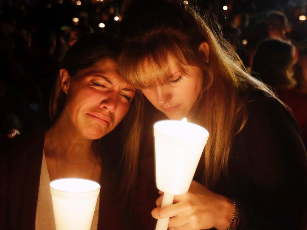 PHOTO: Kristen Sterner, left, and Carrissa Welding, both students at Umpqua Community College, embrace each other during a candlelight vigil for those killed during a shooting at the college, Oct. 1, 2015, in Roseburg, Ore.