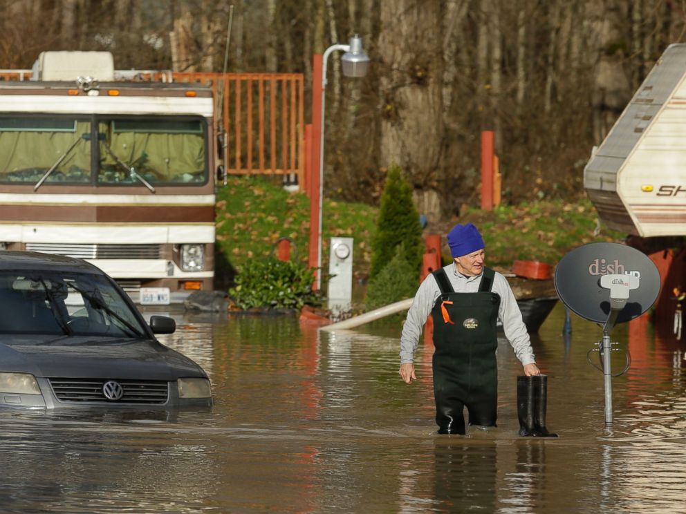PHOTO:Mike Ewing, co-owner of the Riverview RV Park, wades through floodwaters near a partially submerged car, Dec. 9, 2015, in Puyallup, Wash., after he hooked up a pump to get rid of water that flooded RVs and other vehicles Wednesday morning.