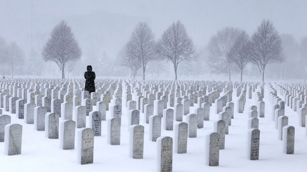 A woman visits a gravesite in the Fort Snelling National Cemetery during a snowstorm in Minneapolis, March 23, 2016.